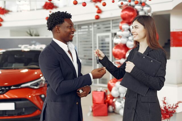 A customer is getting the key for their new car.